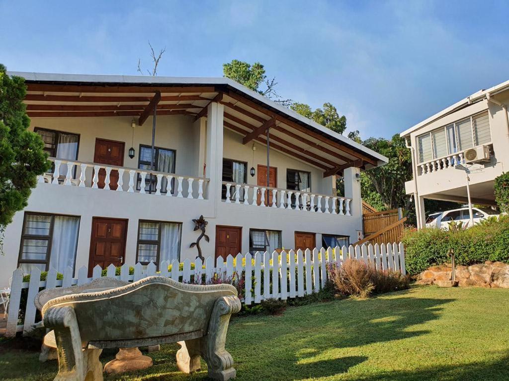 a house with a fence and a bench in front of it at Sunrise Guesthouse in Greytown