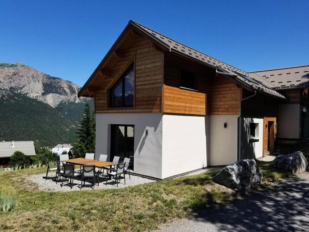 a house with a table and chairs in front of it at Chalet - Magnifique chalet d'architecte 10 pers MAE-2774 in Les Prés