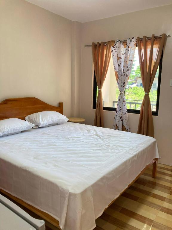 a bedroom with a large white bed and a window at Simon Guest House in San Juan