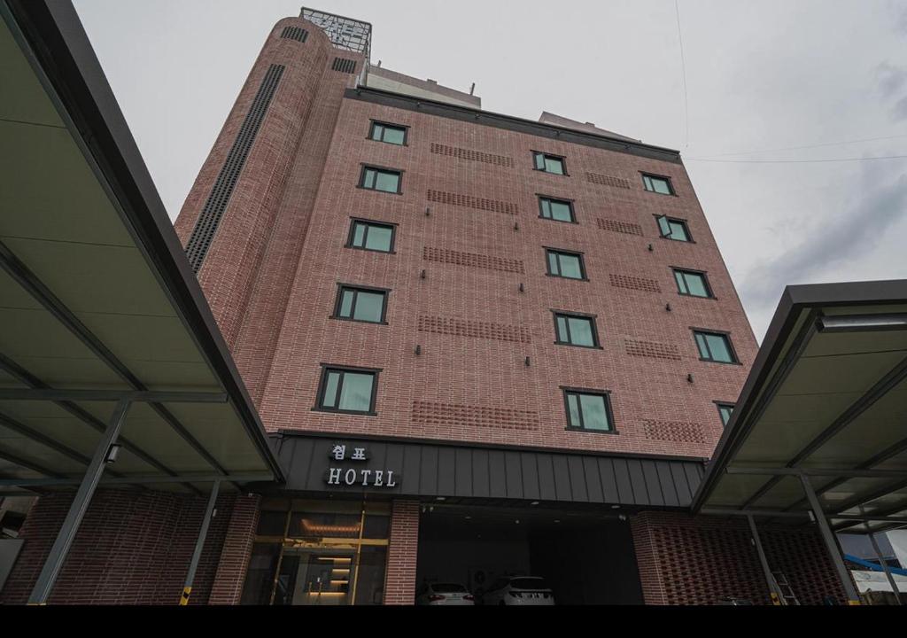a tall red brick building with a hotel at Daejeon Comma Hotel in Daejeon