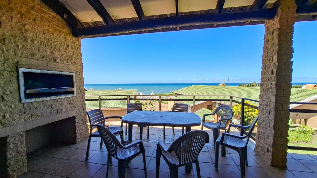a table and chairs on a patio with a view of the ocean at Allesreg Chalet B2 in Margate