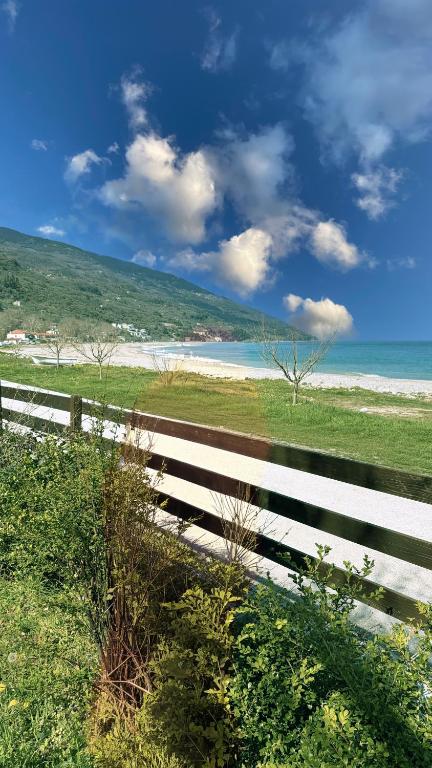 a fence next to a beach with the ocean at Duchess Eva's Seafront Guesthouse in Chorefto