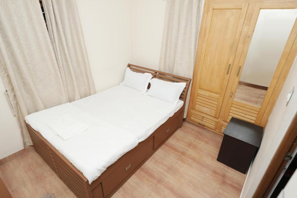 a small bedroom with a bed and a door at Spicened inn in Cochin