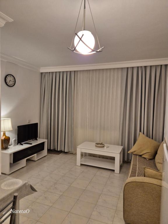 a living room with a couch and a tv at Aygun Apart 4 in Mahmutlar