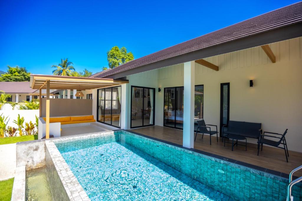 a villa with a swimming pool and a house at FarmSaijai Kohphangan in Hinkong
