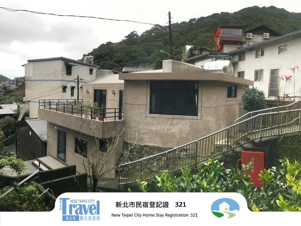 a house with a balcony in a city at Lucky House B&B in Jiufen