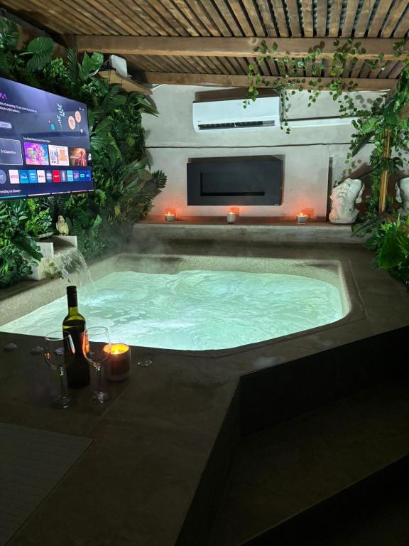 a hot tub in a backyard with a tv and a television at Studio Nessa with a private jacuzzi in Krk