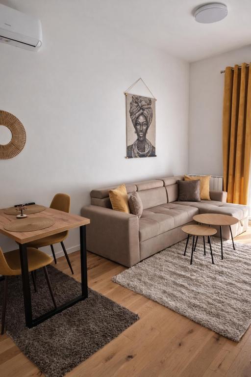 a living room with a couch and a table at Ilma Apartmani Musique in Tuzla