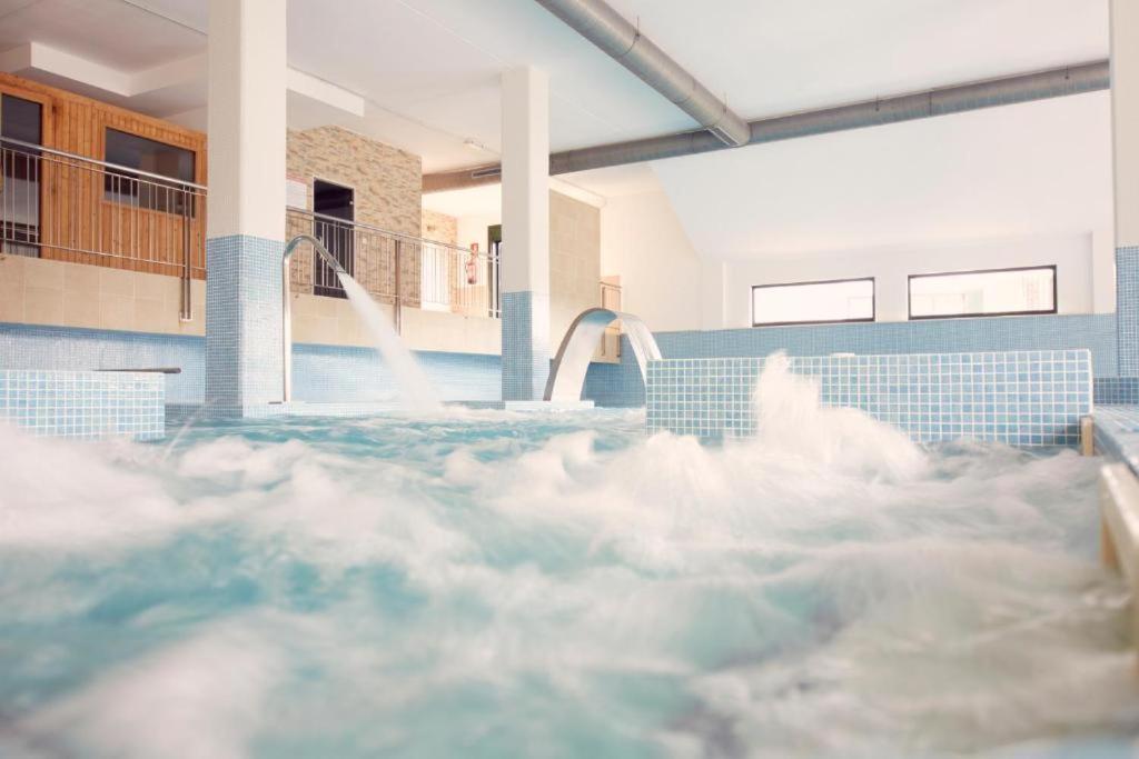 a swimming pool with clouds in the water at Paraiso Spa Reinante in San Miguel de Reinante