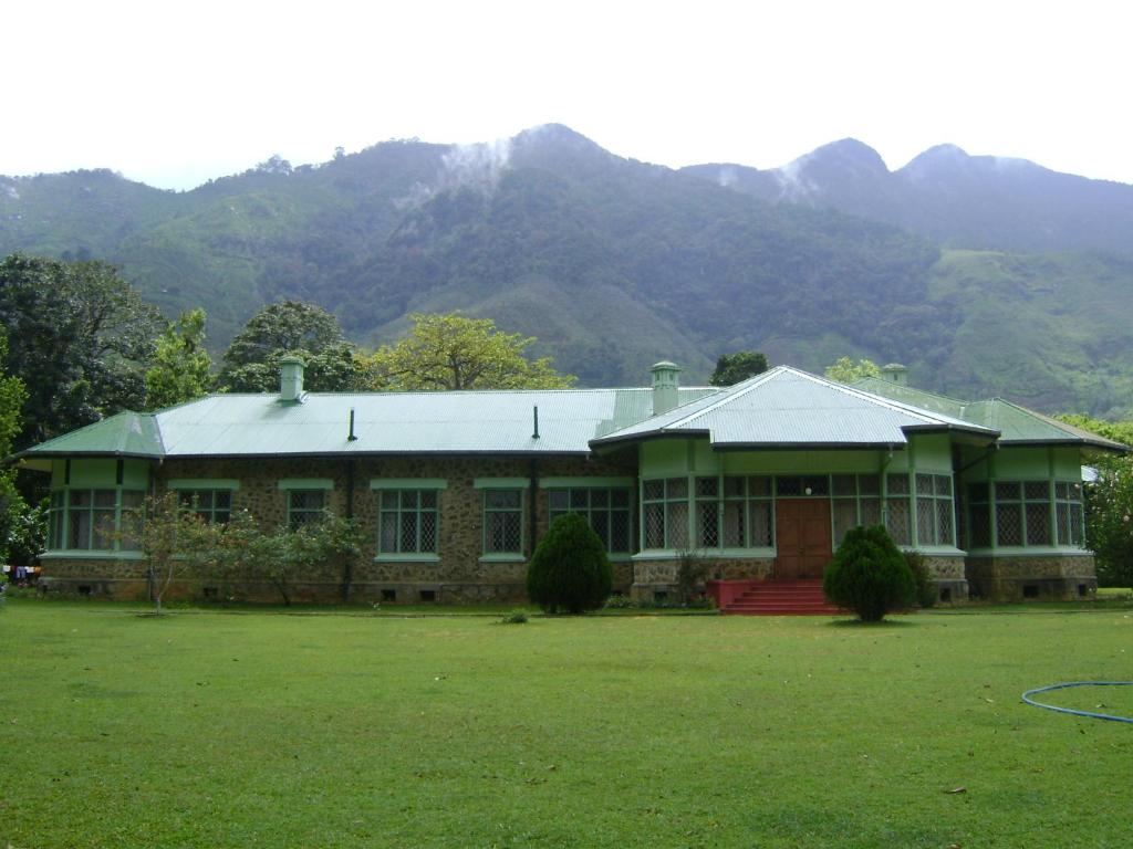 a large house with mountains in the background at Morris Bungalow in Passara