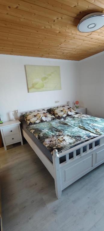 a bed in a room with a wooden ceiling at Alpenblick in Trofaiach