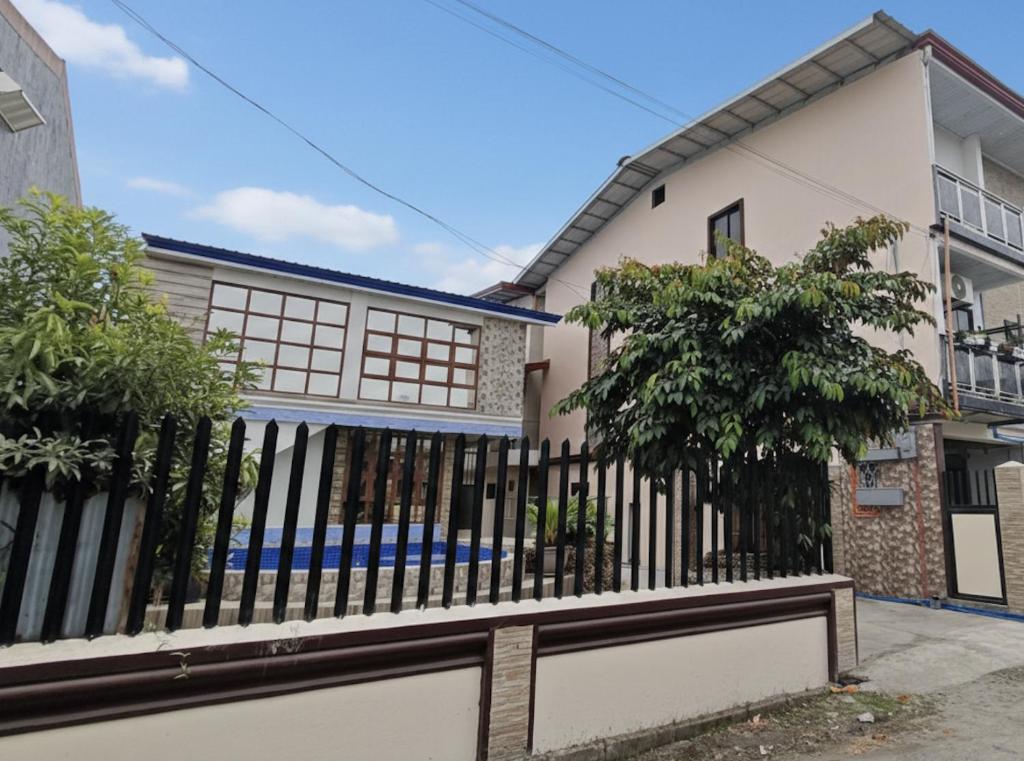 a fence in front of a house at Koenigs Lodging House in Bocaue