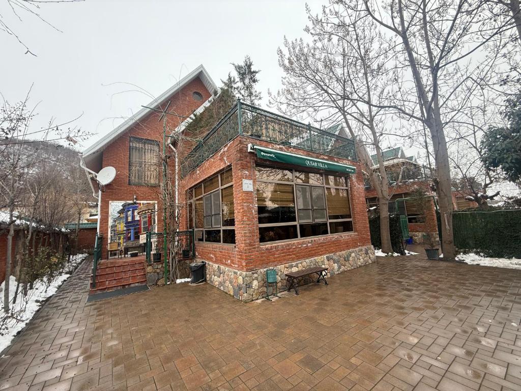 a brick building with a bench in front of it at Villa lux in Qusar