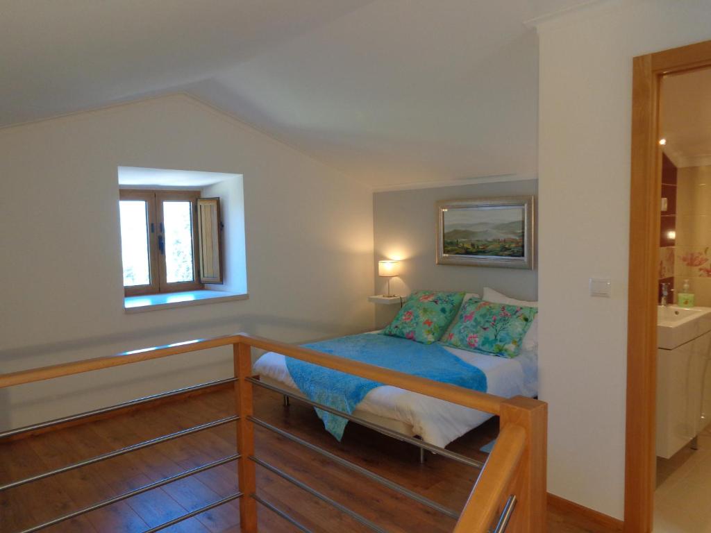 um pequeno quarto com uma cama e uma janela em Oak Cottage em Ferreira do Zêzere