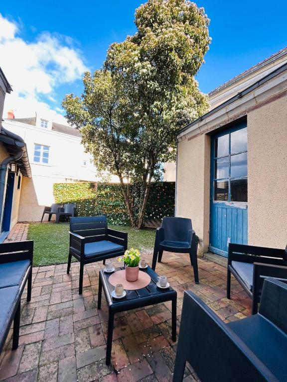 a patio with benches and a table and a tree at Casa Douce Angevine in Angers