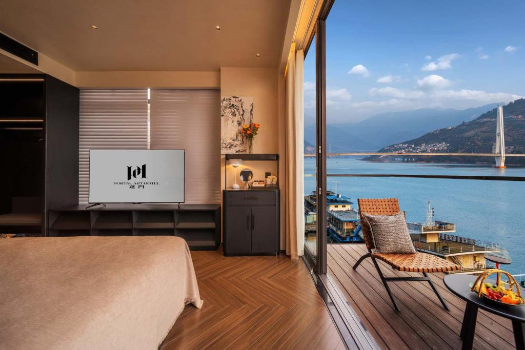 a bedroom with a bed and a view of the water at PORTAL ART HOTEL in Fengjie