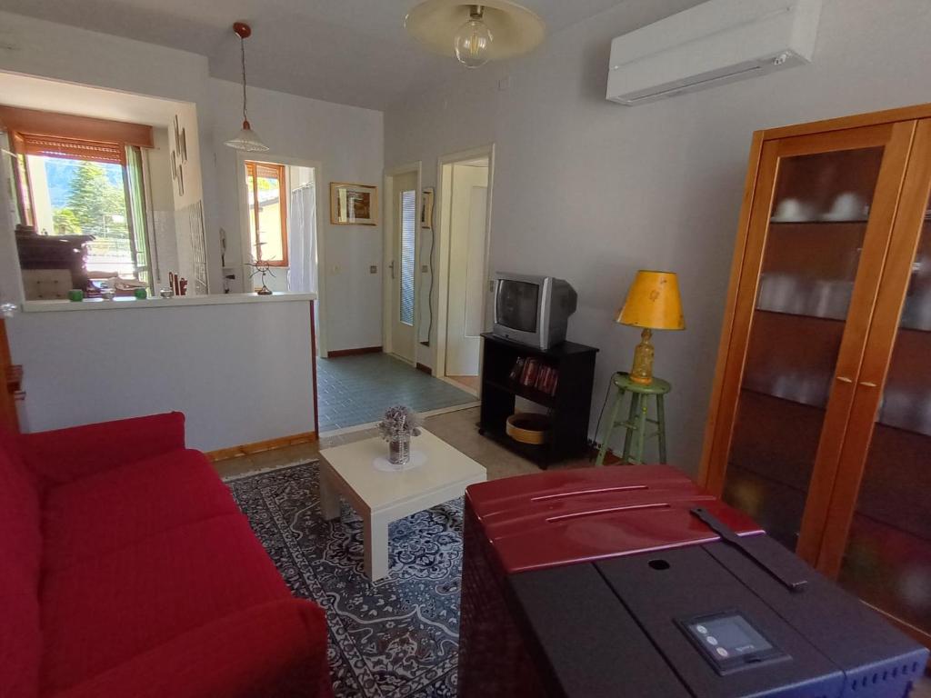 a living room with a red couch and a tv at Casa Noemi in IDRO