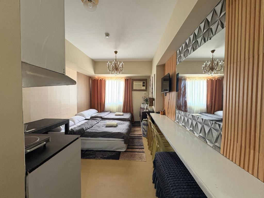 a kitchen and a living room with two beds in a room at Avida Aspira Tower 1 - Chads Unit 8th Floor in Cagayan de Oro