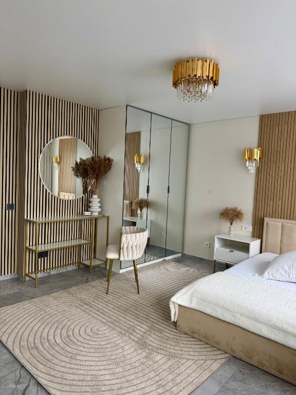 a bedroom with a bed and a mirror and a chair at Baltic Avenue Duo in Klaipėda