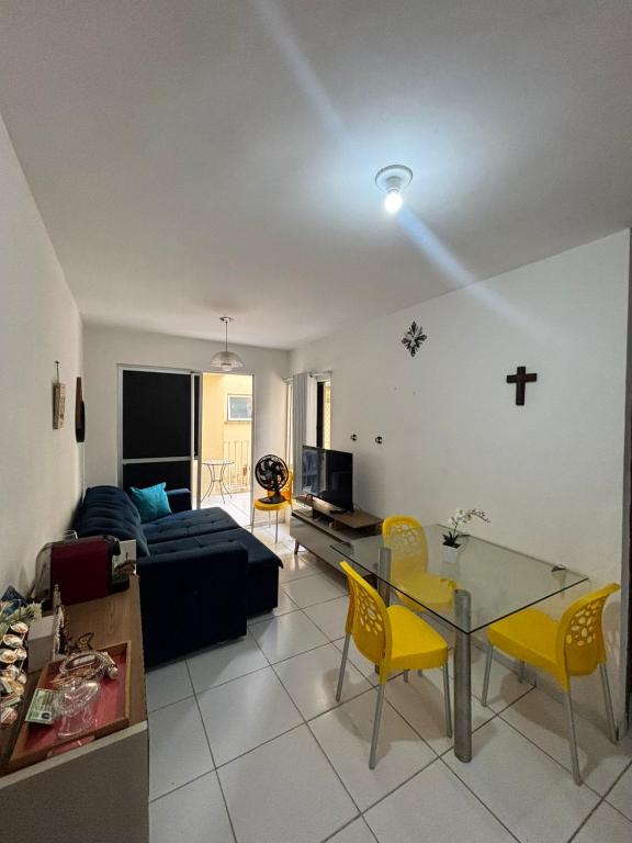 a living room with a couch and a table and yellow chairs at Condomínio Aurora in Paulista