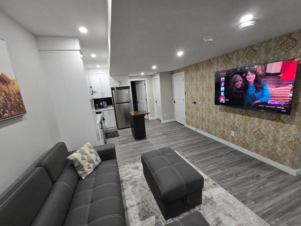 a living room with a couch and a flat screen tv at Cozy 2 Bedroom basement Suite in Calgary