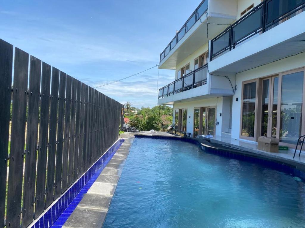 a house with a swimming pool next to a fence at Bahtera Canggu in Dalung