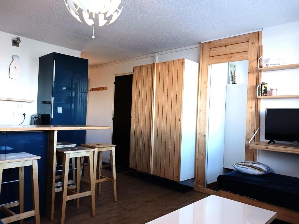 a living room with a kitchen with a bar and a tv at Résidence Cachette - Superbe 2 pièces cabine 4 personnes à Arc 1600, proche des pistes et proche des commerces MAE-7831 in Arc 1600