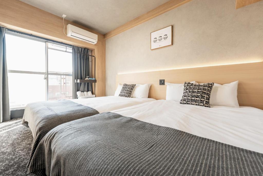 two beds sitting next to each other in a bedroom at b&新大阪店 in Osaka
