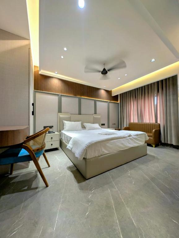 a bedroom with a large bed and a chair at Hotel Classic in Pānīpat