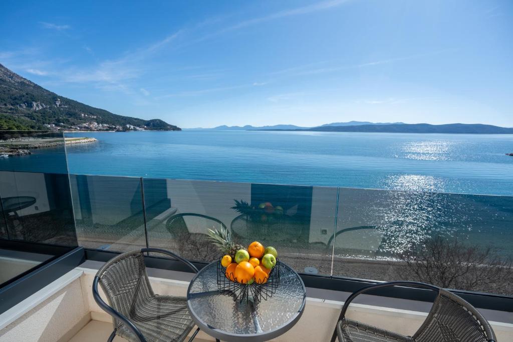 a table with a bowl of fruit on a balcony at Wind Rose Maestral-beachfront in Igrane