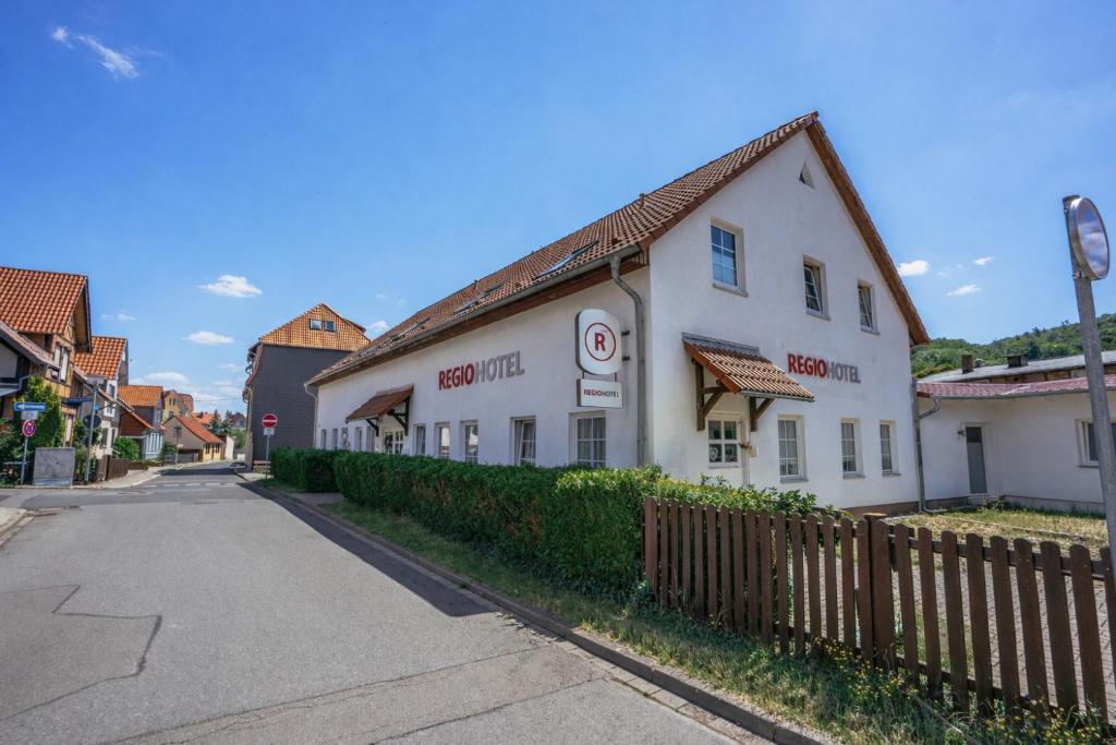 a white building on the side of a street at REGIOHOTEL Aparthotel Wernigerode in Wernigerode
