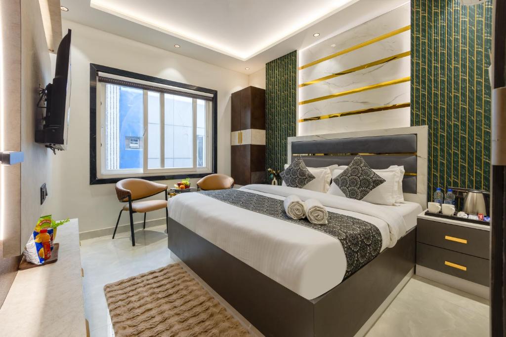a bedroom with a large bed and a desk at Hotel Byland Inn- Near Connaught Place And 5 Minutes From New Delhi Station in New Delhi
