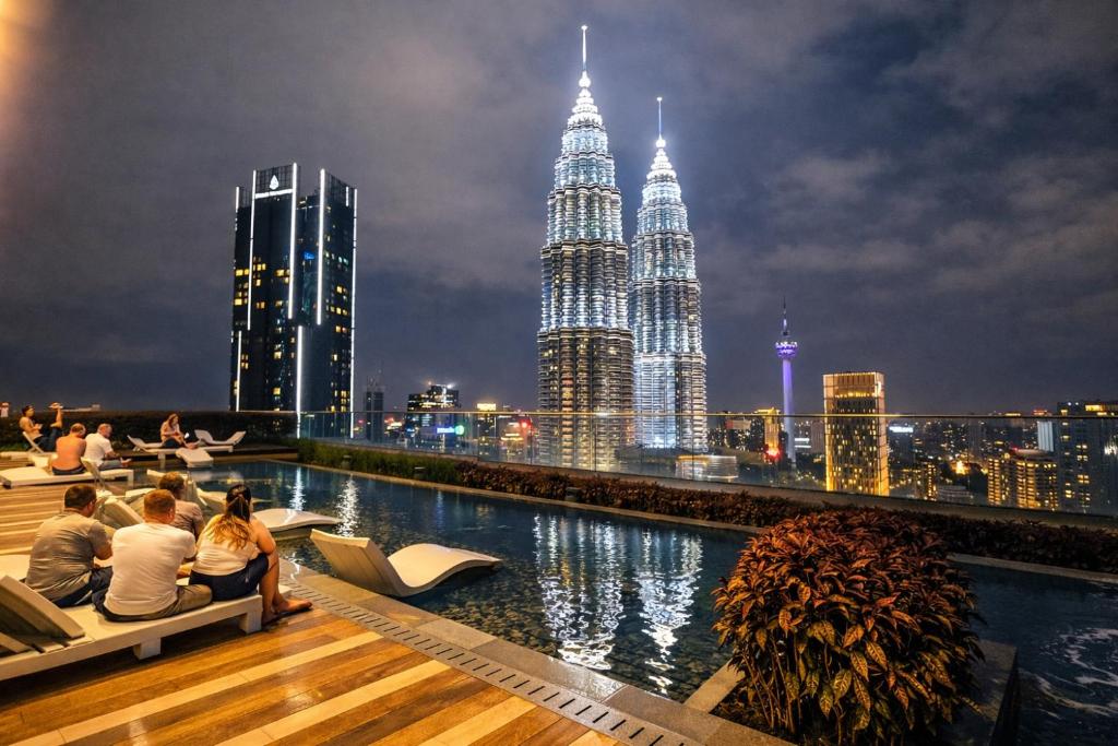 a group of people sitting on a rooftop overlooking the city at klcc Star residence Kuala Lumpur in Kuala Lumpur