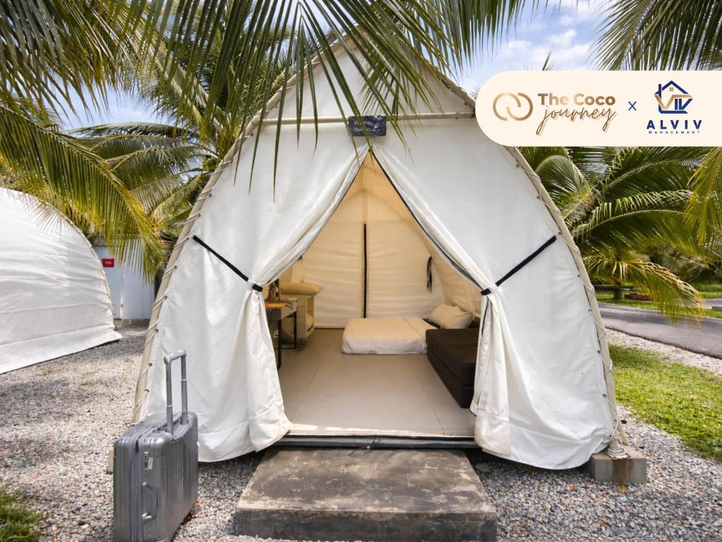 a white tent with a bed and a suitcase at The Coco Journey - Eco Tent in Kelebang Besar