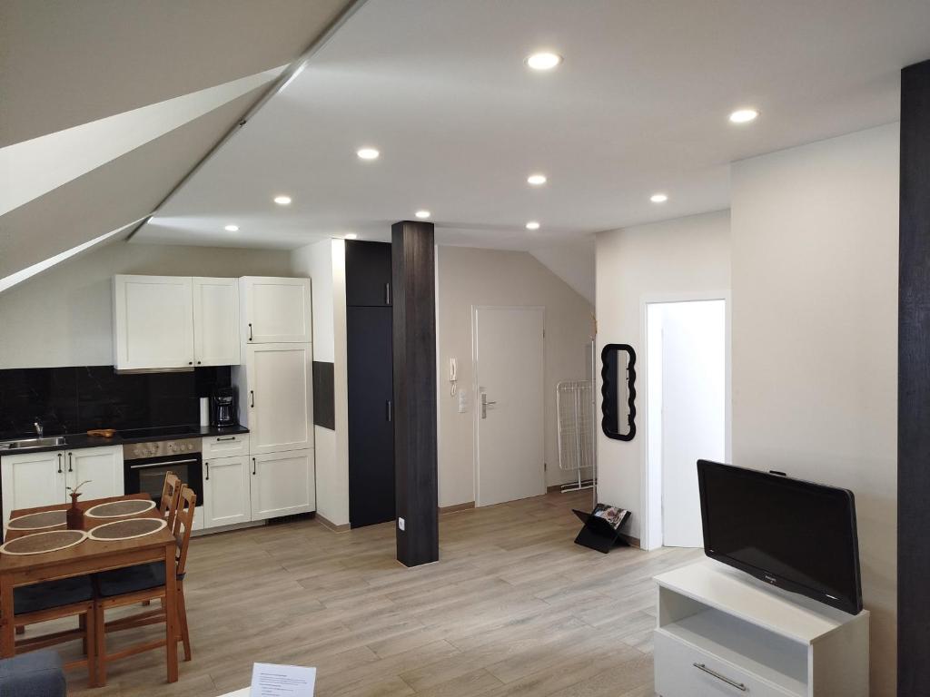 a kitchen and living room with a table and a tv at Appartement Design 2 - Altenstadt in Altenstadt