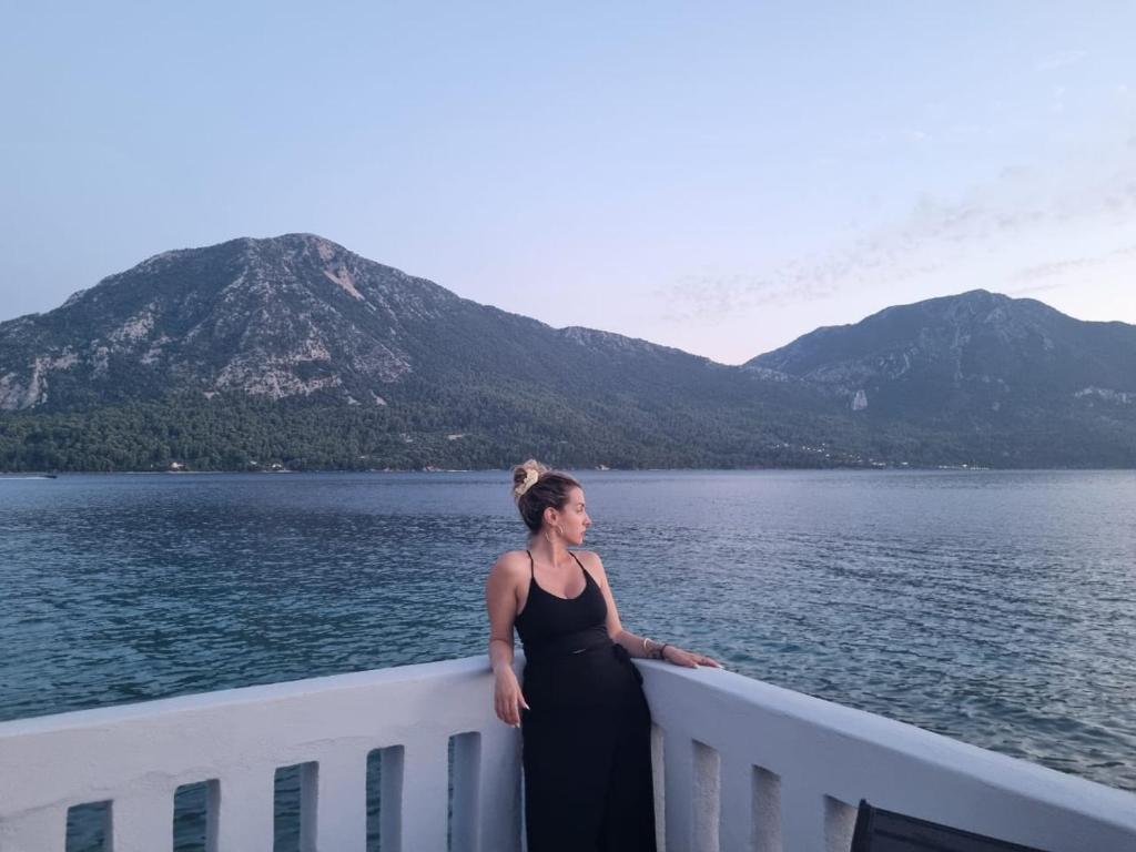 a woman standing on a balcony overlooking a body of water at Blue Horizon Residence in Mitika