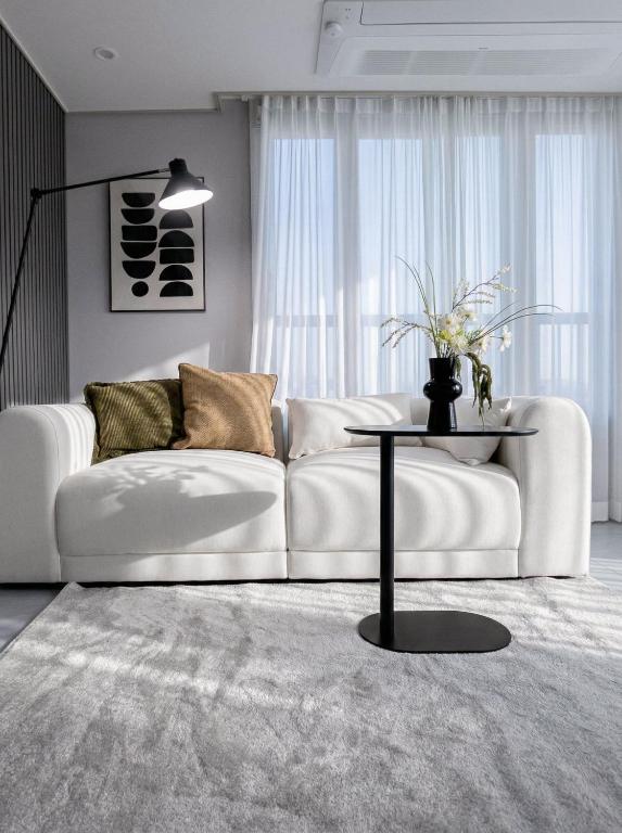 a living room with a white couch and a table at Seoul 3R,4B,2BA,All rooms AC, 지하철도보5분, 동대문15분, 명동25분, 이태원,성수,서울역 30분 in Seoul