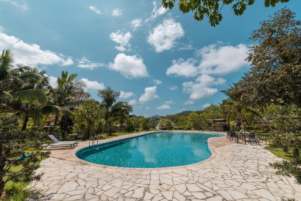 a pool at a resort with palm trees at Sim Forest Resort in Phú Quốc