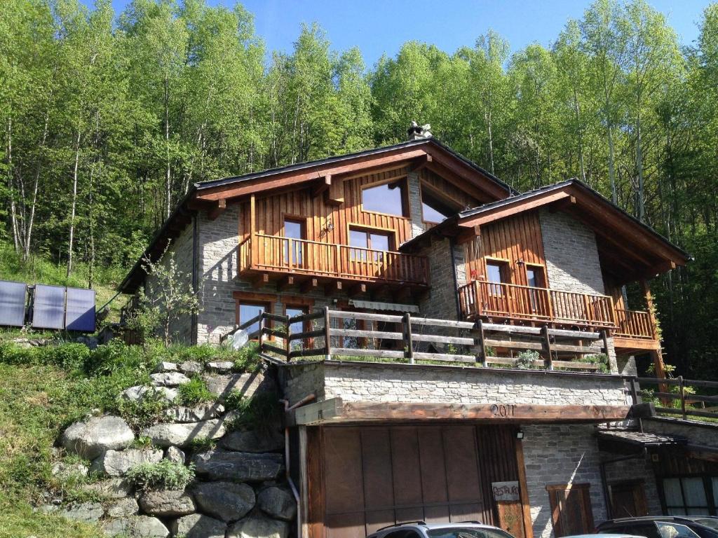a log cabin with a balcony on top of it at Artemisia Eco-Pet friendly B&B in La Salle