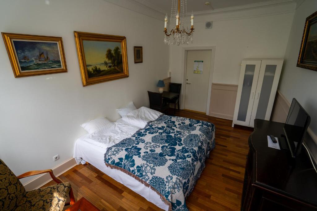 a bedroom with a bed with a blue and white blanket at Hotel Allegade 10 in Copenhagen