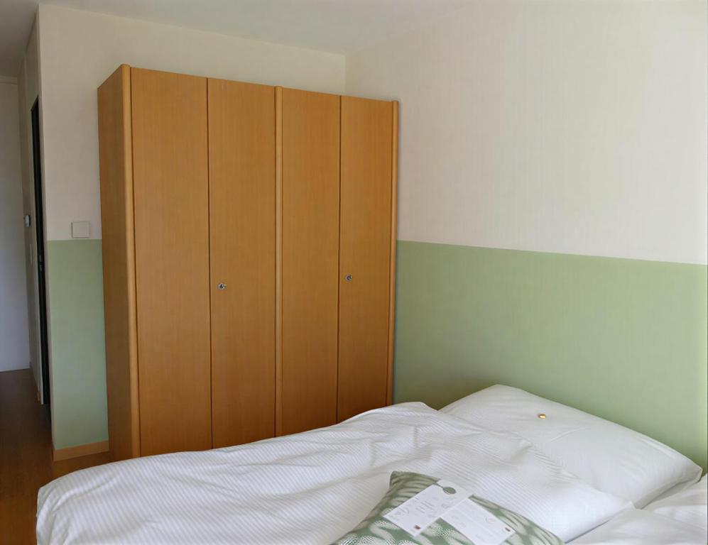 a bedroom with a bed and a wooden cabinet at Gästehaus Gutenberg - Self-Check-in in Balzers