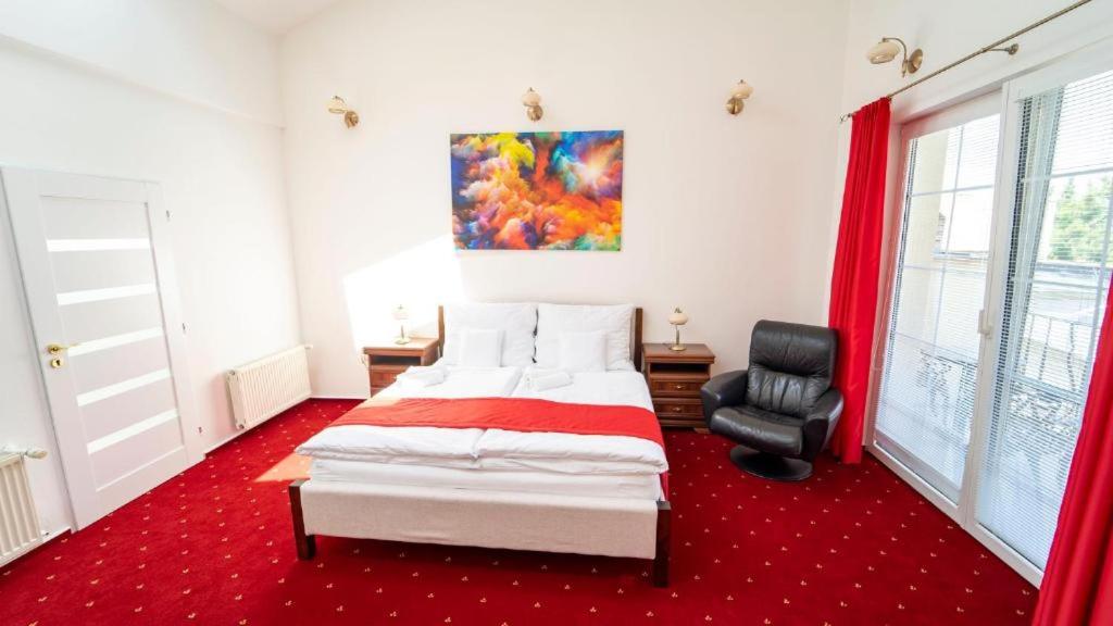 a bedroom with a bed and a chair in it at Penzion Rosel Nové Zámky in Nové Zámky