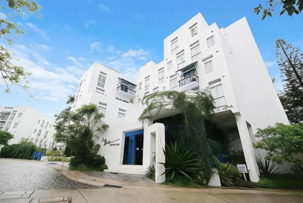 a white building with palm trees in front of it at La Bella Boutique Hotel in Tagaytay