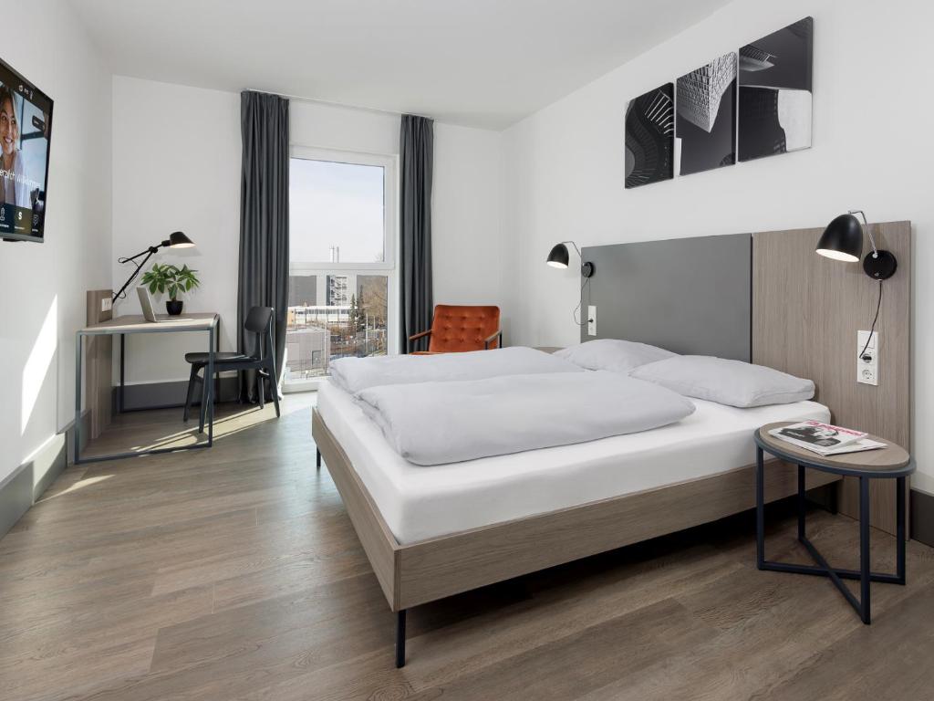 a bedroom with a bed and a desk and a chair at smartments Frankfurt City-Ost in Frankfurt