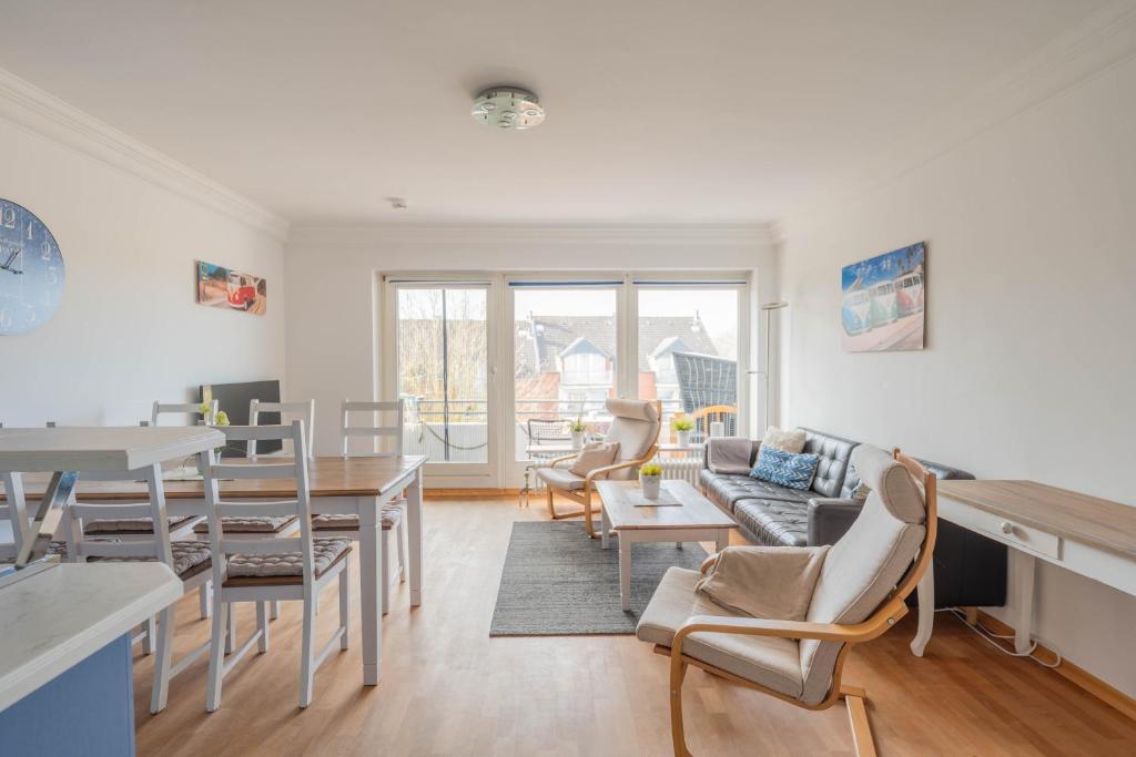 a living room with a table and chairs at Küstenglück in Neustadt in Holstein