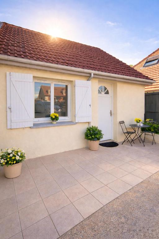 a patio with two potted plants and a house at Le petit nid de St-Germain in Saint-Germain