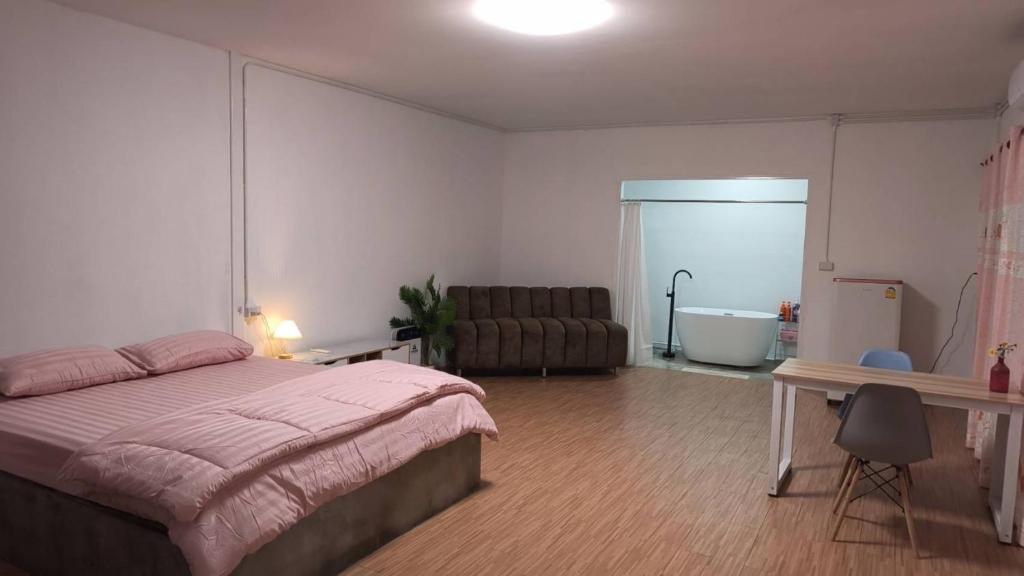 a bedroom with a bed and a bathroom with a tub at บ้านสวนร่มไม้แอ๊ดเชียงดาว in Ban Hua Thung
