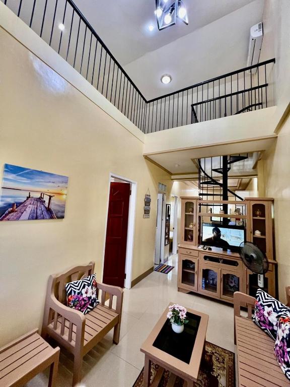 a living room with two chairs and a tv at Nielo's Apartment Door 5 in Dapitan