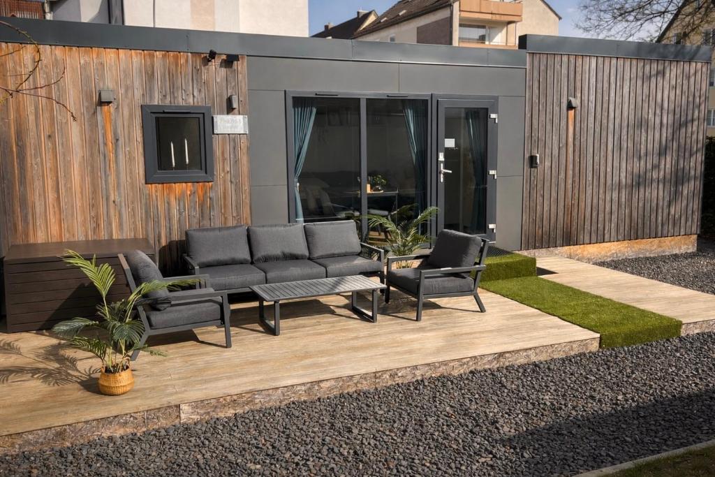 a patio with chairs and a table and a building at Tiny House mit Terrasse und Garten in Altstadtnähe inkl Parkplatz in Weiden