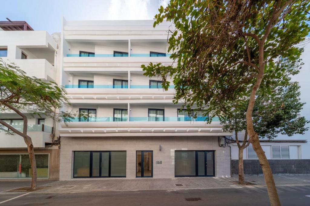 an apartment building with trees in front of it at Ereza Suites in Arrecife